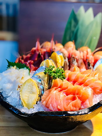 Close-up of a delicious sashimi platter featuring salmon and shrimp, served on ice with garnishes. HD phone wallpaper