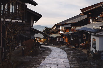 Explore the serene beauty of a traditional Japanese village street at dawn. HD wallpaper