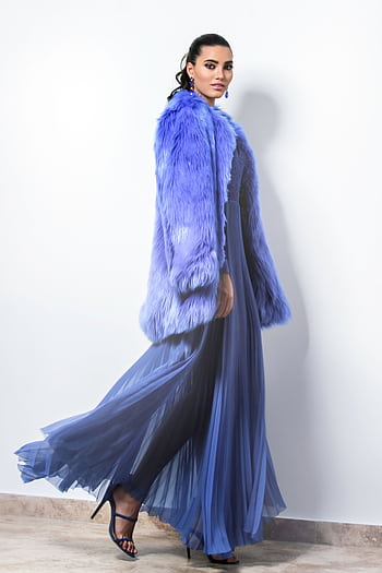 Stylish woman wearing a flowing blue dress with a matching fur coat, posing confidently indoors. HD phone wallpaper
