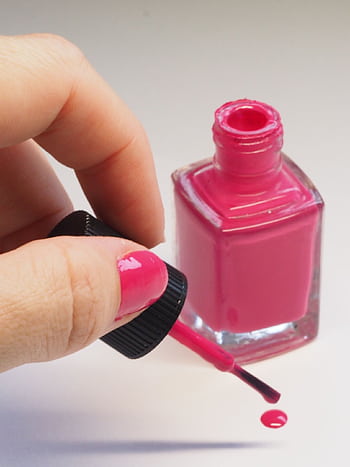 Female hand applying bright pink nail polish from open bottle, minimalistic style. HD phone wallpaper