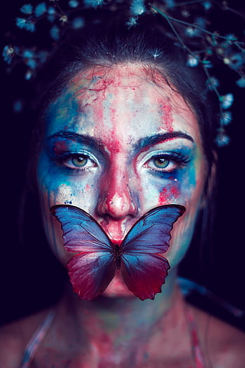 A vibrant artistic portrait featuring a woman with face paint and a butterfly. HD phone wallpaper