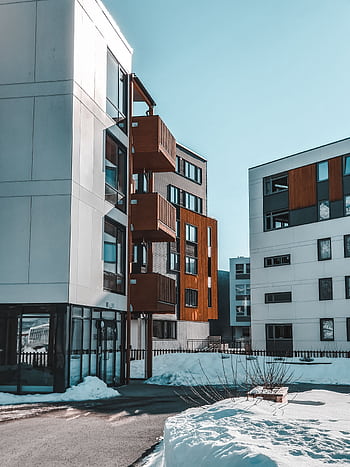 Contemporary apartment buildings with wooden accents in a snowy urban environment. HD phone wallpaper