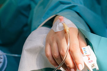 Close-up of a patient's hand with intravenous therapy and pulse oximeter, symbolizing healthcare and treatment. HD wallpaper