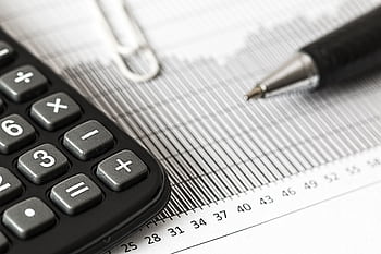 Close-up of a calculator and pen on a bar graph, representing finance and accounting. HD wallpaper