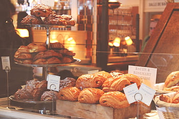 Freshly baked croissants and pastries displayed in a cozy New York City bakery. HD wallpaper