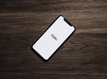 A smart displaying 'Hello' on a wooden surface, showcasing modern technology. HD wallpaper
