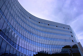 Contemporary glass building in Tiranë, showcasing modern urban architecture. HD wallpaper