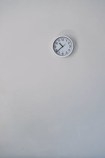 A minimalist white wall clock against a plain background, showcasing simple design. HD phone wallpaper