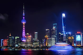 Stunning night view of Shanghai skyline with illuminated skyscrapers and the Oriental Pearl Tower reflecting in the water. HD wallpaper