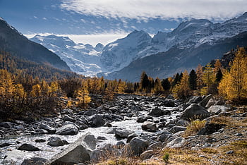 Beautiful autumn landscape of a rocky stream with snowy mountain peaks in the background. HD wallpaper