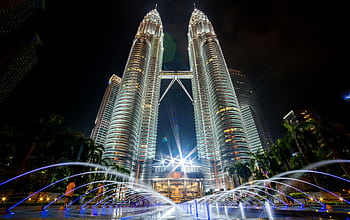 Stunning night view of the illuminated Petronas Twin Towers in Kuala Lumpur with fountains in the foreground. HD wallpaper