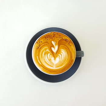 Top view of a beautifully crafted latte with intricate art in a ceramic cup on a neutral background. HD phone wallpaper