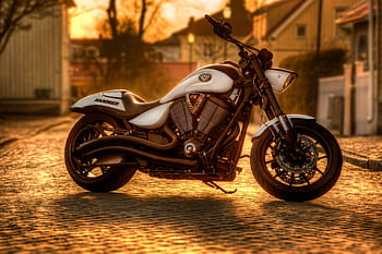 Majestic motorcycle bathed in warm sunset light on a cobbled street in Norra Skara, Sweden. HD wallpaper