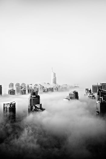 Stunning black and white panorama of Dubai skyline shrouded in fog, showcasing modern skyscrapers. HD phone wallpaper