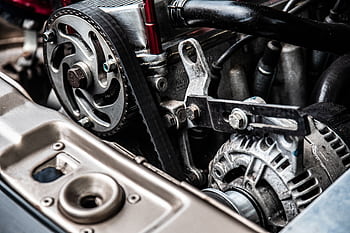 High-resolution close-up of a car engine showing intricate mechanical parts and metallic details. HD wallpaper