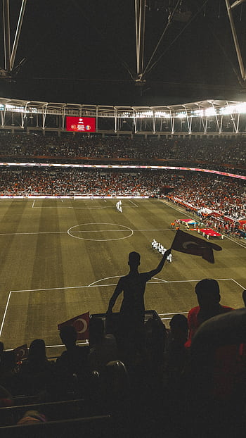 Exciting night soccer game with fans cheering in a vibrant stadium arena. HD phone wallpaper