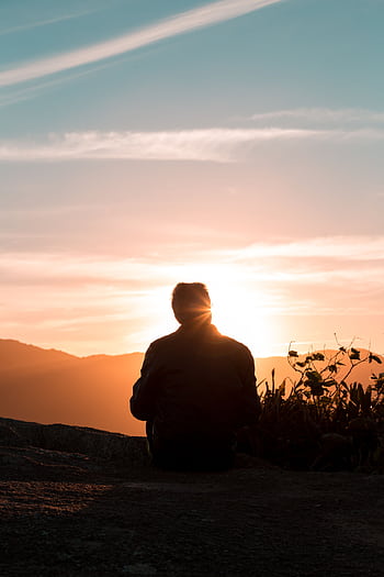 A lone person sitting and enjoying the scenic view of sunset on a hilltop. HD phone wallpaper