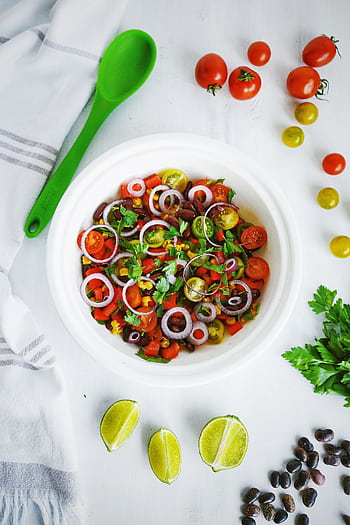 A vibrant salad with tomatoes, onions, and herbs, perfect for a fresh meal. HD phone wallpaper