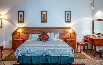Stylish bedroom featuring wooden furniture and soft lighting for a warm ambiance. HD wallpaper