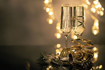 Champagne glasses with ribbons against festive bokeh lights. HD wallpaper