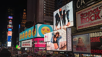 Colorful billboards light up New York City's iconic Times Square at night, with vibrant ads and bustling crowds. HD wallpaper