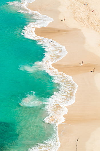 Stunning aerial view of a turquoise ocean meeting a sandy beach, perfect for a relaxing getaway. HD phone wallpaper