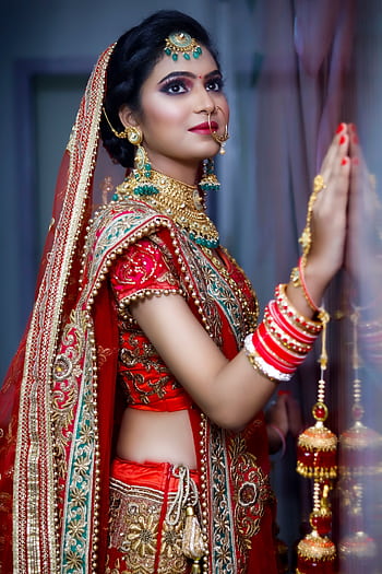 Stunning portrait of an Indian bride in vibrant red and gold attire. HD phone wallpaper