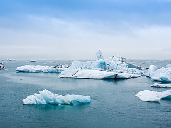 Serene view of icebergs floating in the calm waters of Jokulsarlon Lagoon, Iceland. HD wallpaper