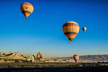 Vibrant hot air balloons soaring above the stunning landscapes of Cappadocia, Turkey. HD wallpaper
