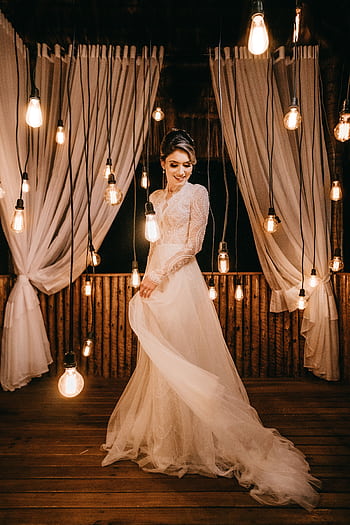 A stunning bridal hoot featuring a model in a white gown surrounded by hanging lights and curtains. HD phone wallpaper
