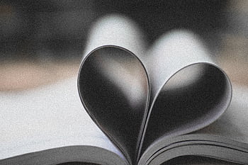 Open book pages forming a heart shape, symbolizing love and creativity. HD wallpaper