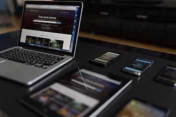 A contemporary workspace showcasing a laptop, tablet, and smarts, ideal for tech and lance use. HD wallpaper