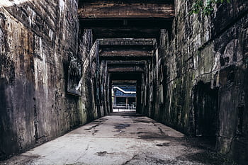 Explore the textured decay of an abandoned urban passageway, revealing industrial history. HD wallpaper