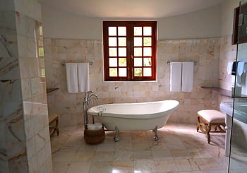 Luxurious bathroom featuring a classic standing bathtub and marble tiles. HD wallpaper
