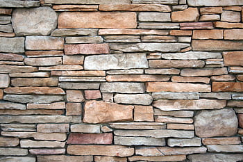 High-resolution of a natural stone wall with various textures and earthy tones. HD wallpaper