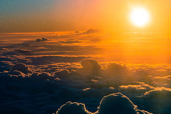 Stunning aerial view of a dramatic sunset over thick clouds, glowing horizon. HD wallpaper
