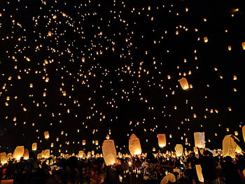 A mesmerizing scene of sky lanterns illuminating the night during a festive gathering, creating a magical atmosphere. HD wallpaper