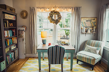 A bright and cozy home office with vintage decor, bookshelves, and natural light. HD wallpaper