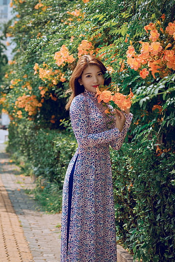 Asian woman in a floral dress posing in a vibrant flower garden during daylight. HD phone wallpaper