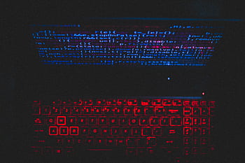 Dark-themed laptop setup with a red glowing keyboard and code on screen, ideal for tech enthusiasts. HD wallpaper
