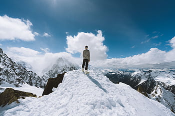 Person standing on a snow-covered peak in Chamonix-Mont-Blanc, France, showcasing a breathtaking mountain view. HD wallpaper