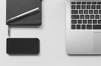 Modern minimalist workspace featuring a laptop, smart, and notebook on a desk. HD wallpaper