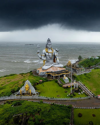 A breathtaking aerial view of the Shiva statue at Murdeshwar with stormy skies over the Arabian Sea. HD phone wallpaper