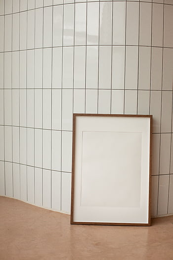 A minimalist interior featuring a blank vertical frame against tiled wall, offering ample copy space. HD phone wallpaper