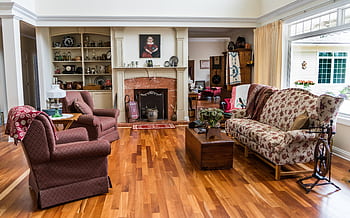 Charming living room featuring classic decor, patterned upholstery, and a cozy fireplace setting. HD wallpaper