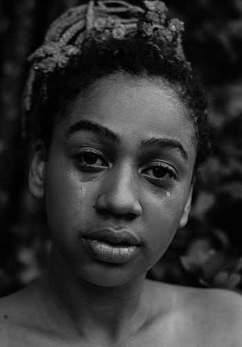 A black and white portrait of a young woman expressing deep emotion with tears. HD phone wallpaper