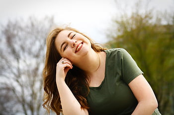 A care woman enjoying a sunny day outdoors, expressing pure happiness and relaxation. HD wallpaper