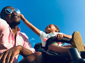 Happy father and daughter bonding moment outdoors under a clear blue sky. HD wallpaper