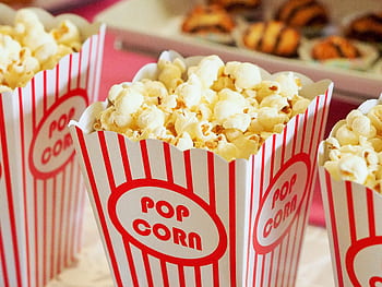 Close-up of gourmet popcorn in classic red and white striped boxes, perfect cinema snack. HD wallpaper
