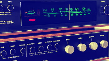 A retro FM-AM stereo tuner with knobs and wooden accents, embodying vintage audio equipment. HD wallpaper